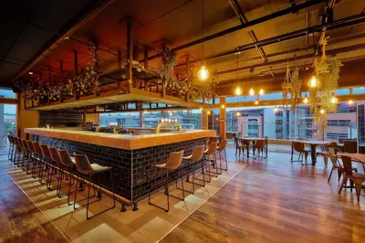a bar in a restaurant with chairs and tables at Protea Hotel by Marriott Pretoria Loftus Park in Pretoria
