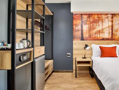 a bedroom with a bed and a book shelf at Protea Hotel by Marriott Pretoria Loftus Park in Pretoria