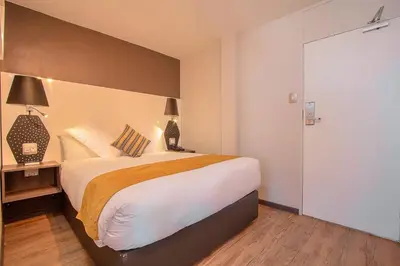 a bedroom with a large bed with a wooden floor at THE Pretoria Hotel in Pretoria