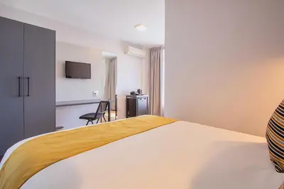 a hotel room with a bed and a television at THE Pretoria Hotel in Pretoria