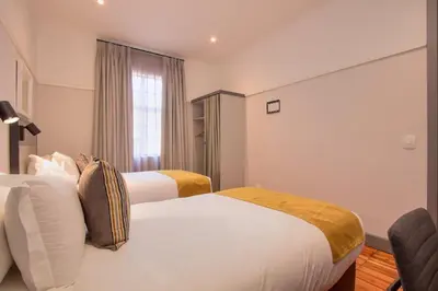 a hotel room with two beds and a window at THE Pretoria Hotel in Pretoria
