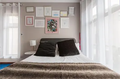 a bedroom with a bed with black pillows on it at Alimama Spaces: Manson Mansion in Randjesfontein