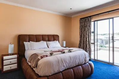 a bedroom with a large bed with a large window at Alimama Spaces: Manson Mansion in Randjesfontein