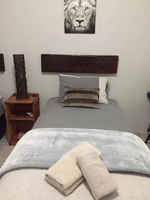 a bedroom with a bed with a towel on it at Burgersfort Gastehuis in Burgersfort
