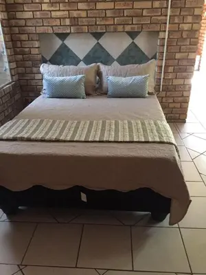 a large bed with two pillows on top of it at Burgersfort Gastehuis in Burgersfort