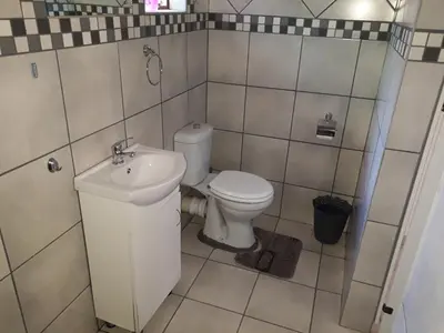 a bathroom with a toilet and a sink at Burgersfort Gastehuis in Burgersfort