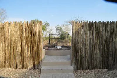 a wooden fence with a fire pit behind it at Ngalas Rest 101 in Hectorspruit