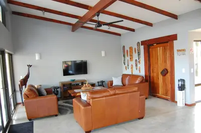 a living room with leather furniture and a flat screen tv at Ngalas Rest 101 in Hectorspruit