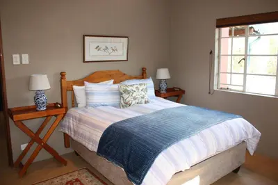 a bedroom with a bed with two lamps and a window at The Red Barn in Weimershoek