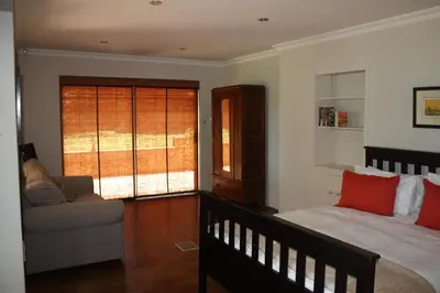 a bedroom with a bed and a couch and a window at The Red Barn in Weimershoek