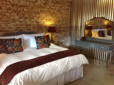 a bedroom with a large white bed with a mirror at The Red Barn in Weimershoek