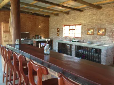 a bar in a restaurant with a wooden table and chairs at The Red Barn in Weimershoek