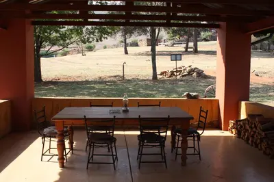 a table and chairs in a room with a view of a field at The Red Barn in Weimershoek