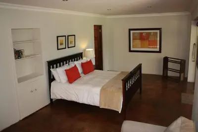 a bedroom with a large bed with red pillows at The Red Barn in Weimershoek