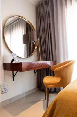 a dressing table with a mirror and a chair in a room at The Wilcrest Apartment in Randjesfontein