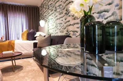a living room with a glass table with vases on it at The Wilcrest Apartment in Randjesfontein