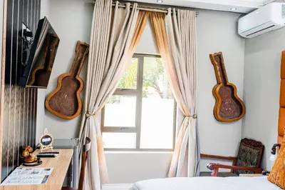 a bedroom with two guitars on the wall and a window at Re-Union Vacations in Hartbeespoort