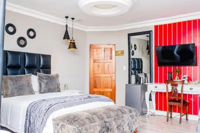a bedroom with a bed and a red wall at Re-Union Vacations in Hartbeespoort