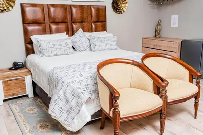a bedroom with a large bed with two chairs at Re-Union Vacations in Hartbeespoort