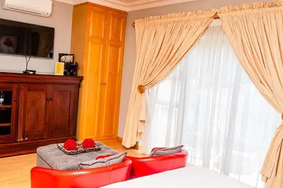 a bedroom with two red chairs and a large window at Re-Union Vacations in Hartbeespoort