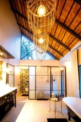a living room with a chandelier and a table at Kings Camp in Timbavati Game Reserve