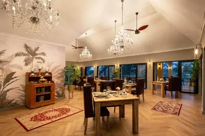 a dining room with a table and chairs and chandeliers at Kings Camp in Timbavati Game Reserve