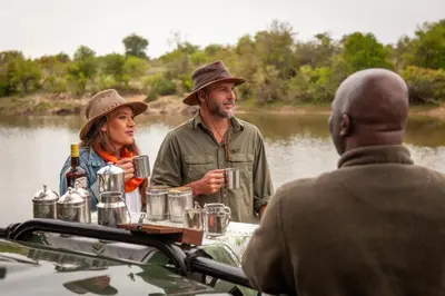 a group of people sitting in a boat on a river at Kings Camp in Timbavati Game Reserve