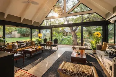 an open living room with large windows and furniture at Kings Camp in Timbavati Game Reserve