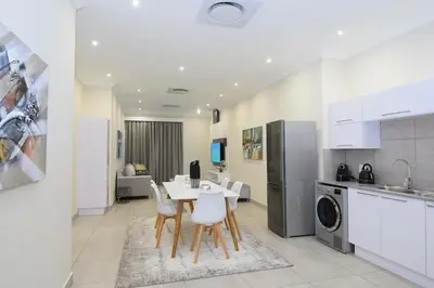 a kitchen and living room with a table and chairs at Elridge Living in Boksburg