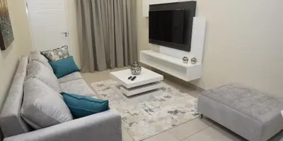 a living room with a couch and a flat screen tv at Elridge Living in Boksburg
