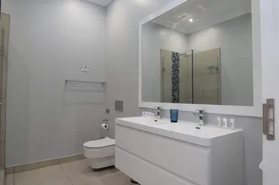 a white bathroom with a sink and a toilet at Elridge Living in Boksburg