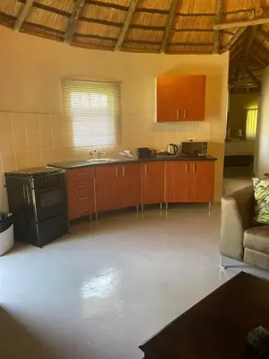 a kitchen with a stove and a couch in a room at Jock of the Bushveld in Barberton