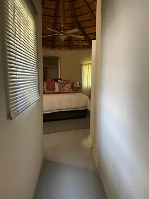 a bedroom with a bed and a window with blinds at Jock of the Bushveld in Barberton