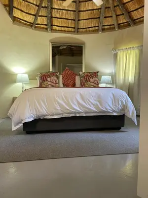 a bedroom with a large bed with a large mirror at Jock of the Bushveld in Barberton