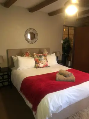 a bedroom with a large bed with a red blanket at Jock of the Bushveld in Barberton