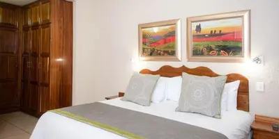 a bedroom with a large bed in a hotel room at Palm Park Hotel in Ellisras