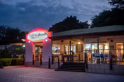 a restaurant with a neon sign at night at Palm Park Hotel in Ellisras
