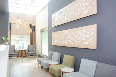 a waiting room with chairs and a painting on the wall at Palm Park Hotel in Ellisras