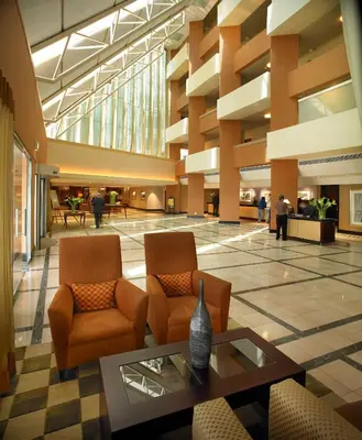 a lobby with chairs and a table in a building at Southern Sun OR Tambo International Airport in Kempton Park