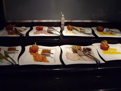 a row of plates of food on a table at Southern Sun OR Tambo International Airport in Kempton Park