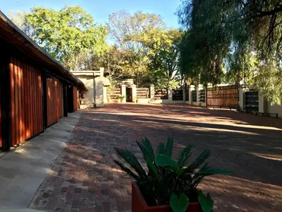 a brick walkway next to a building with a plant at Greenwoods Self-Catering in Pretoria