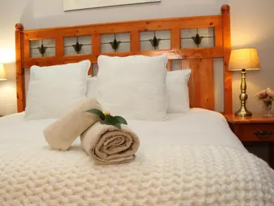 a bedroom with a bed with a towel on it at Feathers Guest House in Middelburg