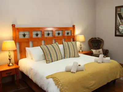 a bedroom with a large bed with two towels on it at Feathers Guest House in Middelburg