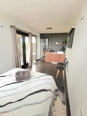 a bedroom with a bed and a chair in it at Arendskop in Pretoria