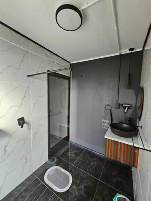 a bathroom with a shower and a toilet and a sink at Arendskop in Pretoria
