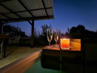 two wine glasses sitting on a table next to a candle at Arendskop in Pretoria