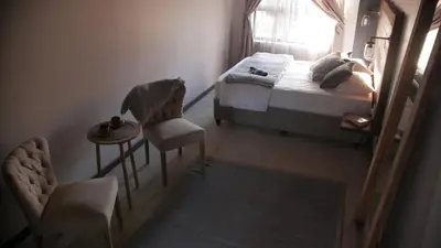 a bedroom with a bed and a chair and a window at Arendskop in Pretoria