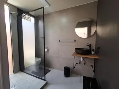 a bathroom with a shower and a sink and a mirror at Arendskop in Pretoria