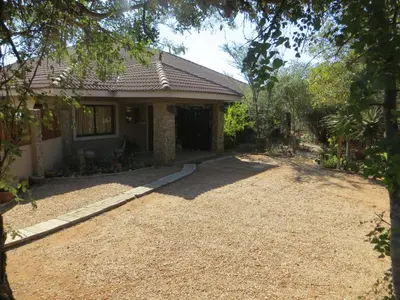 a house with a gravel driveway in front of it at At Rest Bushstay in Hoedspruit