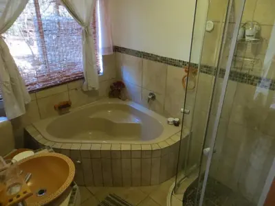 a bathroom with a tub and a sink at At Rest Bushstay in Hoedspruit